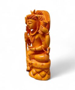 Hand-carved amber deity figurine seated on ornate pedestal.