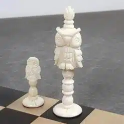 Carved owl chess pieces on a wooden chessboard.
