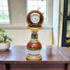 Ornate marble painted pillar watch with gold details on a wooden table.